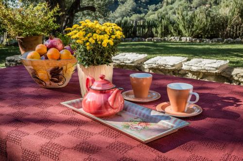 a table with a tea pot and a vase of fruit at Mastrogiannis Villa Levanda in Kavvadádes