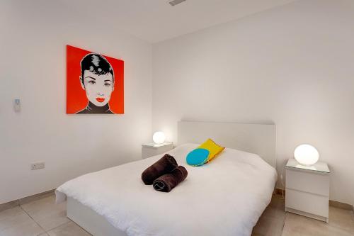 - une chambre avec un lit blanc orné d'une peinture murale dans l'établissement Modern Seaview Apartment In a Prime Location, à Sliema