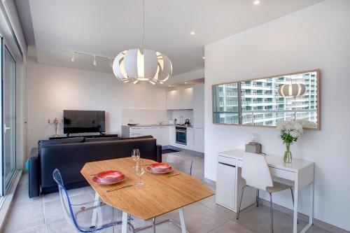 a kitchen and living room with a table and a couch at Modern Seaview Apartment In a Prime Location in Sliema
