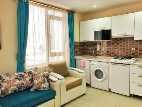 a kitchen with a couch and a washing machine at Osmanlı Suite in Uzungol
