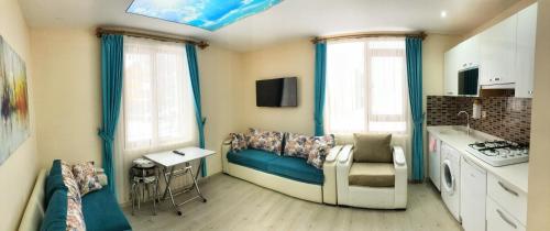 a living room with a blue couch in a kitchen at Osmanlı Suite in Uzungol