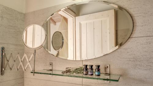 a bathroom with a round mirror and a sink at Mastrogiannis villa Dafne in Kavvadádes