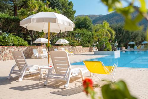 a group of chairs and an umbrella next to a pool at Residence Trivento in Palinuro