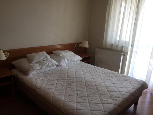 een bed met twee kussens in een slaapkamer bij 2 fős apartman Badacsonytomajon in Badacsonytomaj