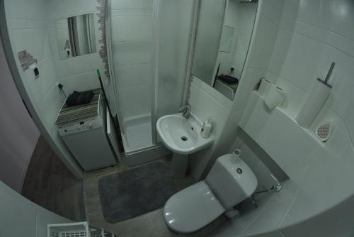 a white bathroom with a toilet and a sink at Kwatery w Cieplicach in Jelenia Góra