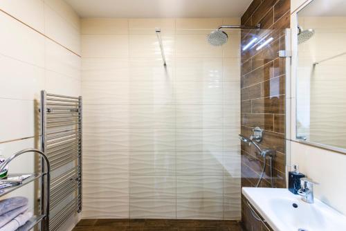 a bathroom with a shower and a sink at Mami Style Apartments in Podtureň