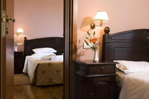 a bedroom with two beds and a table with a lamp at Vytina Mountain View Hotel in Vytina