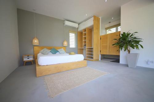 1 dormitorio con 1 cama y una maceta en Cap Heureux Villas, en Cap Malheureux