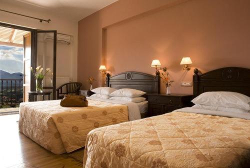 a hotel room with two beds and a balcony at Vytina Mountain View Hotel in Vytina