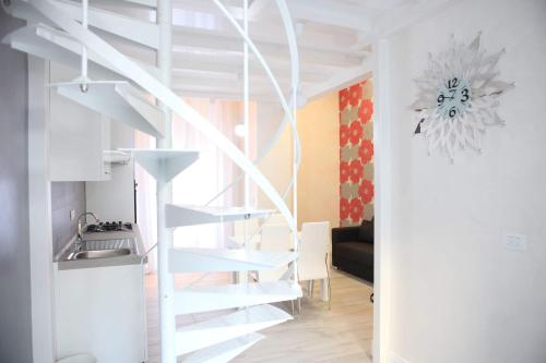 een witte wenteltrap in een kamer met een keuken bij Casa D'Amore in Napels