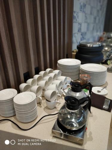 ein Tisch mit weißen Tellern, Tassen und Schüsseln in der Unterkunft Nanu Resort , Arambol in Arambol