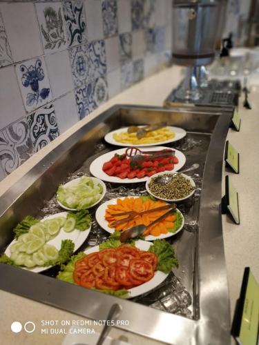 Ein Haufen Teller mit Essen auf einer Theke. in der Unterkunft Nanu Resort , Arambol in Arambol