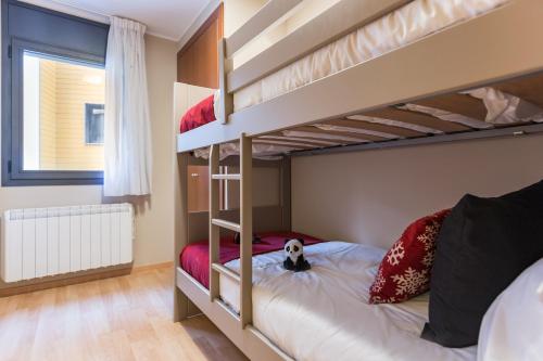 um quarto com beliches e um cão sentado na cama em Pierre & Vacances Andorra El Tarter em El Tarter