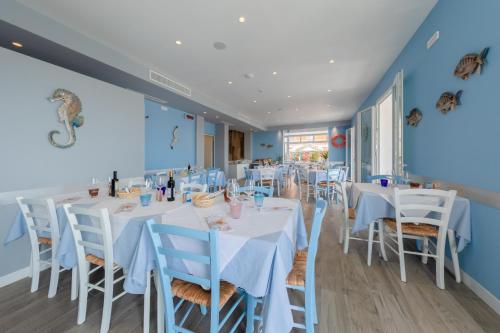 a dining room with white tables and white chairs at Hotel Garni' Serena in Caorle