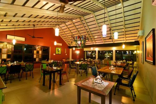 a restaurant with tables and chairs in a room at The Source At Sula in Nashik