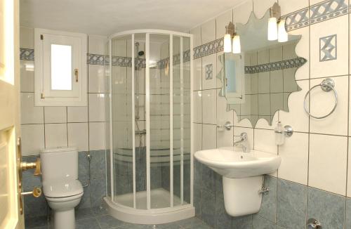 a bathroom with a toilet and a sink and a shower at Parian Holiday Villas in Pounda
