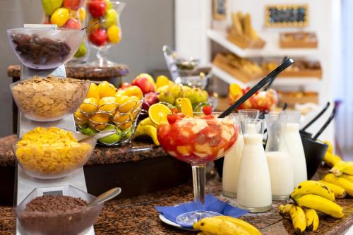 a table topped with bowls of fruit and drinks at Aparthotel Los Dragos del Sur in Puerto de Santiago