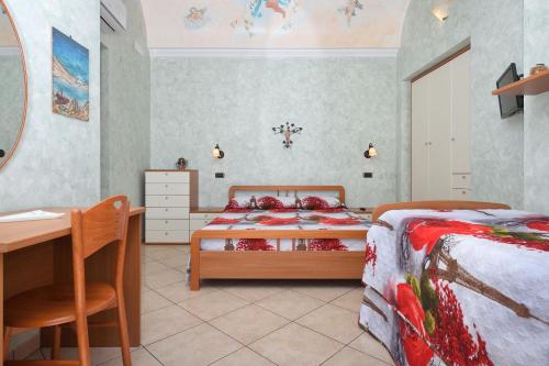 1 dormitorio con 2 camas, mesa y escritorio en Pontone on the sea apartment en Scala