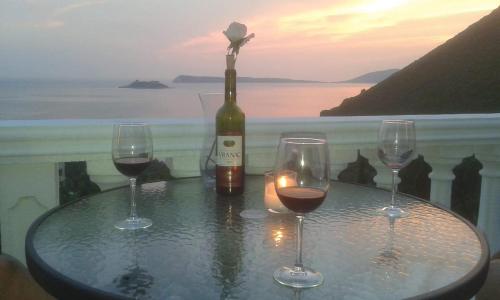 a table with two wine glasses and a bottle of wine at Casa di Zanjic in Lustica