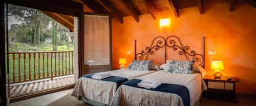 a bedroom with a large bed and a balcony at Alojamientos Rurales Collera in Ribadesella