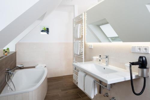 a bathroom with a sink and a bath tub at Hotel am alten Park in Augsburg