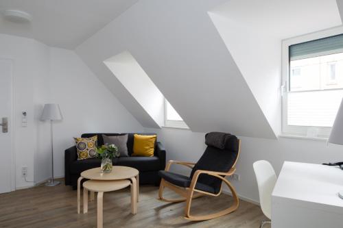 a living room with a couch and two chairs at Hotel am alten Park in Augsburg