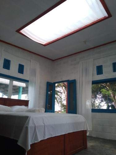 a bedroom with a bed and a skylight at Tanjong Tinggi Cottage in Sijuk