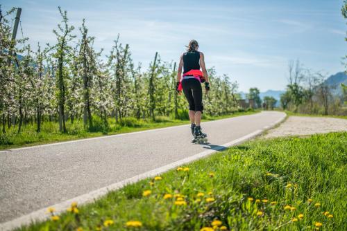 a woman riding a skateboard down a road at Hotel Garni Sonngart in Andrian