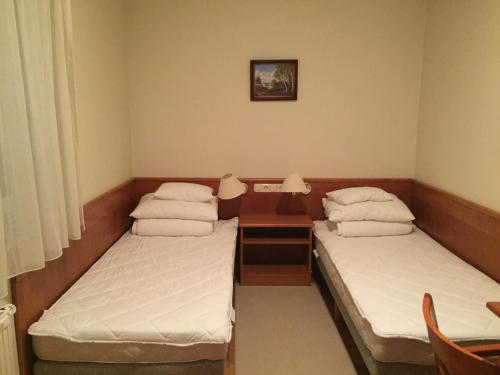Habitación con 2 camas y mesa con espejo. en Vízközeli panorámás 4 fős apartman Badacsonytomajon, en Badacsonytomaj