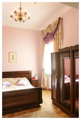 a bedroom with a bed and a chandelier at Pałac Łochów in Łochów