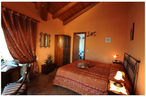 a bedroom with a bed and a desk and a window at Agriturismo Bianconiglio in Monforte dʼAlba