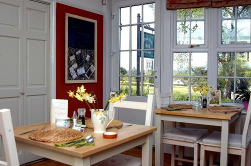 a dining room with two tables and windows at School Farm in Blagdon