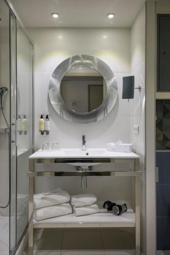 a bathroom with a sink and a mirror at Best Western Plus Ajaccio Amirauté in Ajaccio