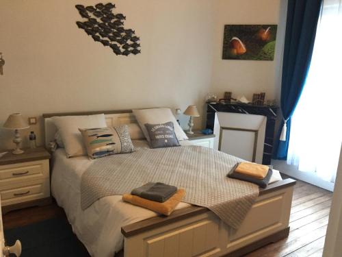 Un dormitorio con una cama con almohadas. en La Homardine, en Monchy-Saint-Éloi