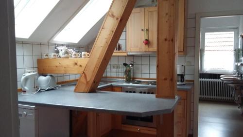 a kitchen with wooden cabinets and a counter with a sink at Ferienhof Cohrs in Bispingen