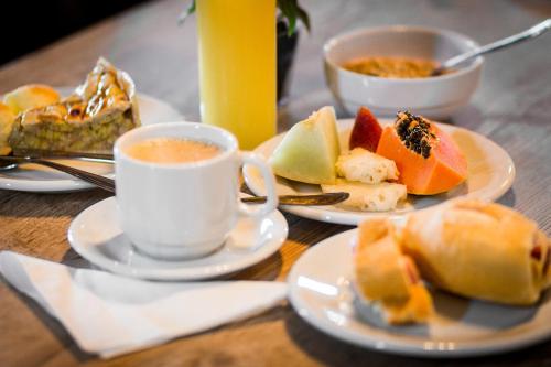 - une table avec des assiettes de nourriture et une tasse de café dans l'établissement Pousada Costa Container, à Penha