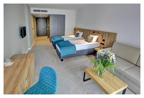 a hotel room with a bed and a couch at Folwark Łochów in Łochów