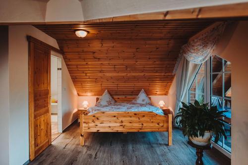 Posto letto in camera con soffitto in legno. di Pension Lehnigksberg a Lübben