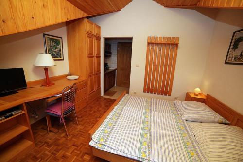 a bedroom with a bed and a desk with a computer at Apartmenthaus Punta **** in Splitska