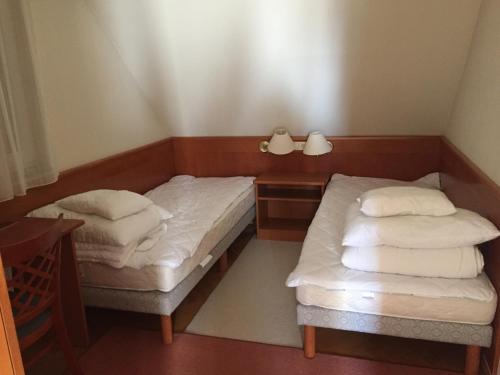 2 camas en una habitación pequeña con sábanas blancas en Strandközeli panorámás 4 fős apartman Badacsonytomajon en Badacsonytomaj