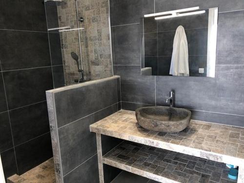 サリ・ソランザラにあるSOLEIL ROUGEのバスルーム(石造りの洗面台、シャワー付)