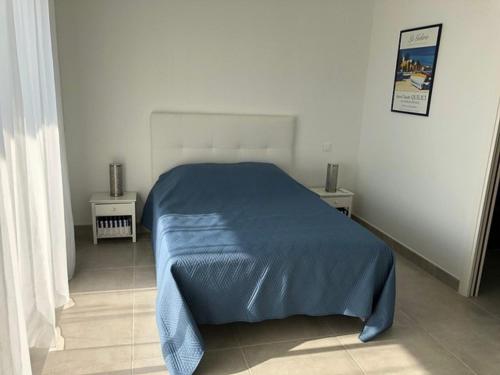 サリ・ソランザラにあるSOLEIL ROUGEのベッドルーム1室(青い毛布付きのベッド1台付)