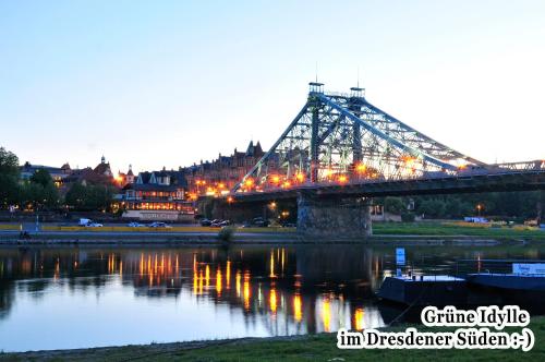 a bridge over a river with a city in the background at Haus Grüne Idylle in Bannewitz