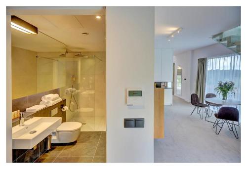 a bathroom with a sink and a toilet and a table at Folwark Łochów in Łochów