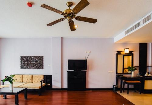 a living room with a ceiling fan and a couch at Ramada by Wyndham Aonang Krabi in Ao Nang Beach