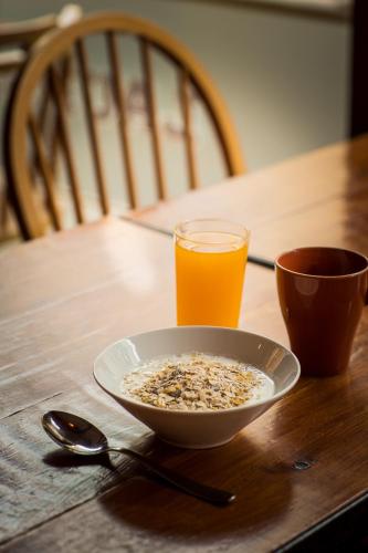 a bowl of cereal and a glass of orange juice on a table at Akureyri Backpackers in Akureyri
