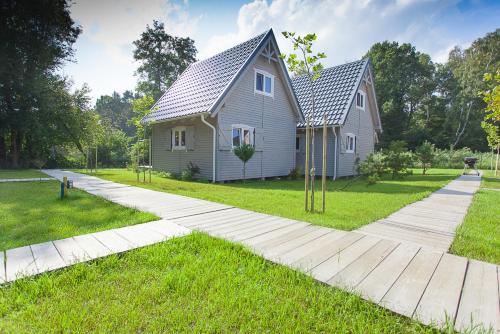 a house with a walkway in front of a yard at fajnemorze - Domy Szwedzkie in Dębina-Ustka