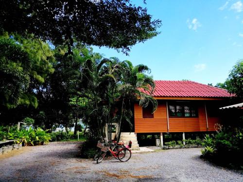 a red bike parked in front of a house at บ้านสนมณีโฮมสเตย์ Bansonmanee Homestay in Khanom