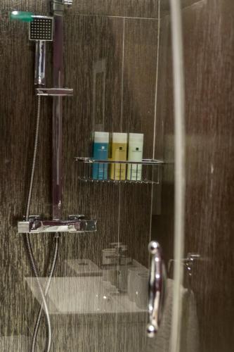 a bathroom with a shower with a rack of toiletries at Garden House in Masham