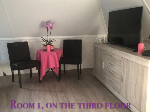 a room with a table with two chairs and a tv at B&B nancy in holland met eigen badkamer , independent bathroom in Aalten